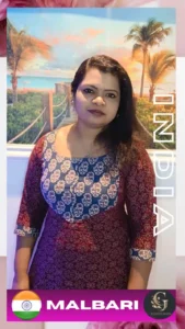 Indian female spa therapist from Malabar wearing a traditional maroon and blue kurti, standing in front of a tropical beach-themed background at Asian Golden Spa, Ras Al Khaimah. The image includes branding with Indian flag and 'Malbari' text, representing her cultural origin and spa role.