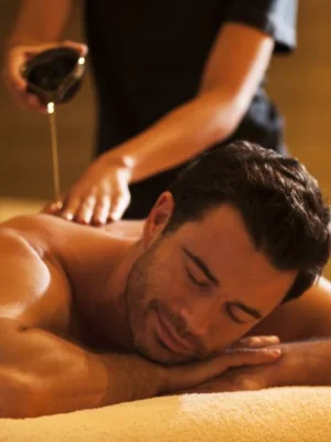 Man enjoying Arabic full body oil massage at Asian Golden Spa, Rak Nakheel Prime Hotel, Ras Al Khaimah – warm oil being poured on back during therapy session